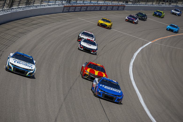 Tyler Reddick chasing Kyle Larson and Ross Chastain on track.