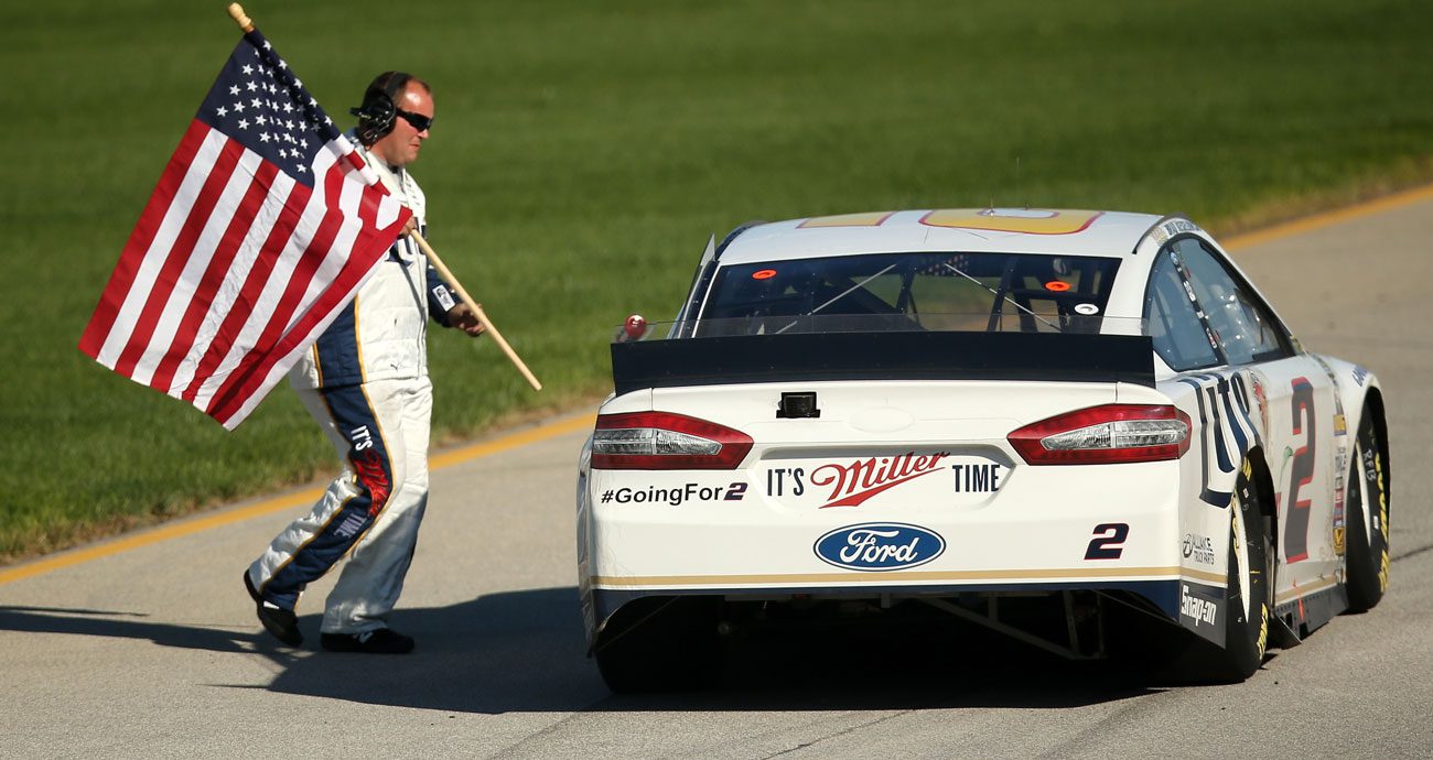 Team Penske No. 2 crew member bring American flag to Brad Keselowski after his win in the 2014 playoff opener at Chicagoland Speedway.