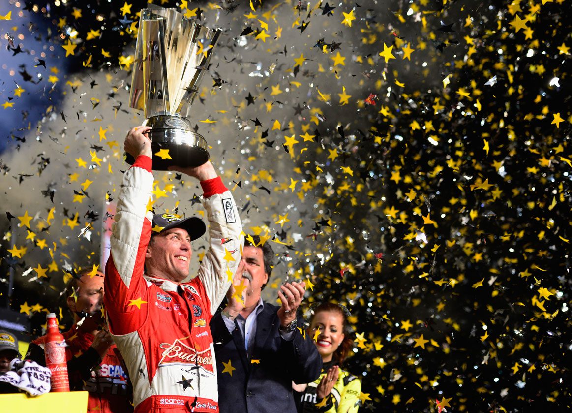 Kevin Harvick holds the 2014 championship trophy above his head