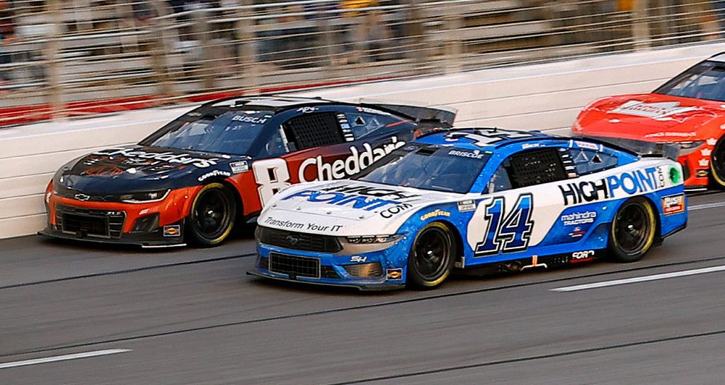 Kyle Busch and Chase Briscoe compete side-by-side in a NASCAR race.
