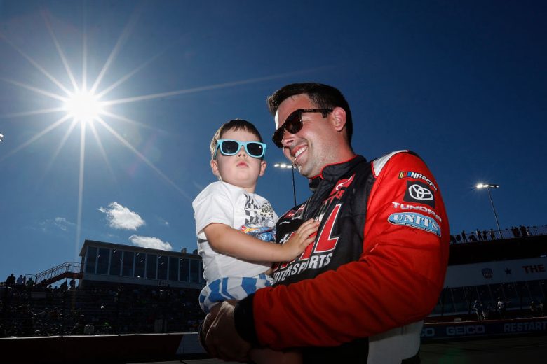 Timmy Hill (R) smiles while holding his son, Hudson Hill.