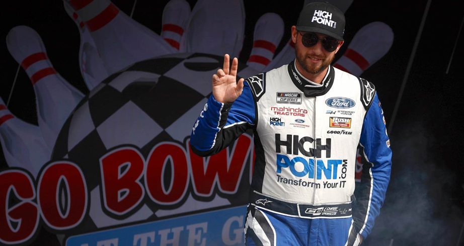 Chase Briscoe walks across the stage and waves to the crowd before a NASCAR Cup Series race at Watkins Glen International.