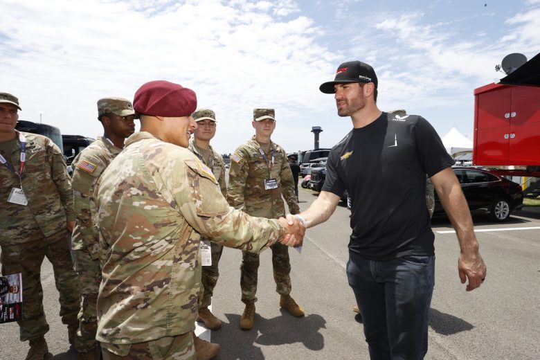 Corey LaJoie shakes the hand of a U.S. military service member.