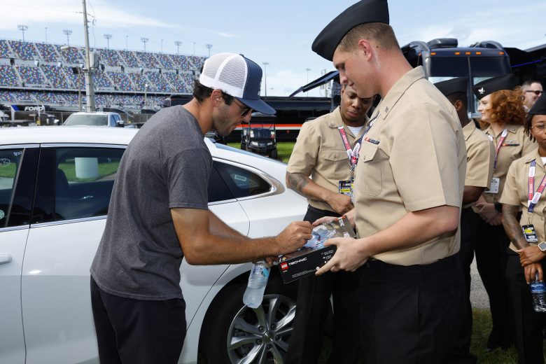 Chase Elliott signs an autograph for a U.S. military service member.