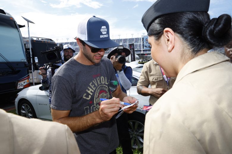 Chase Elliott signs an autograph for a U.S. military service member.