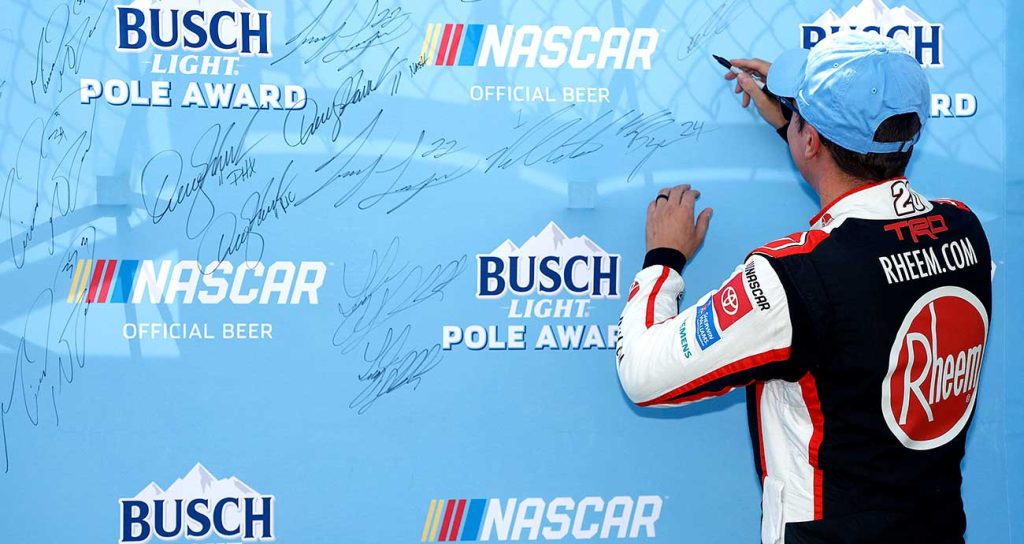 Christopher Bell signs the Busch Light Pole Award board after topping Cup Series qualifying at Kansas Speedway