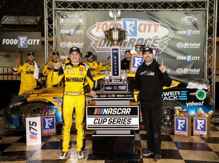 Christopher Bell (L) poses for a photo in Victory Lane at the Bristol Motor Speedway Dirt Course with Adam Stevens (R).