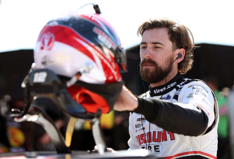 Ryan Blaney places his helmet on the roof of his car at the Charlotte Roval.