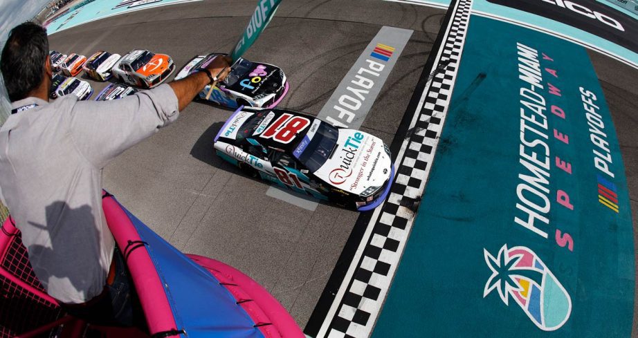 NASCAR Xfinity Series cars cross the start/finish line as the green flag waves at Homestead-Miami Speedway.