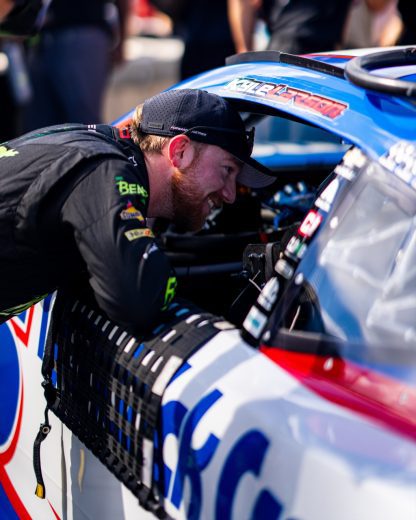 Tyler Reddick leans down to speak to Kyle Larson while in his No. 5 Chevrolet.