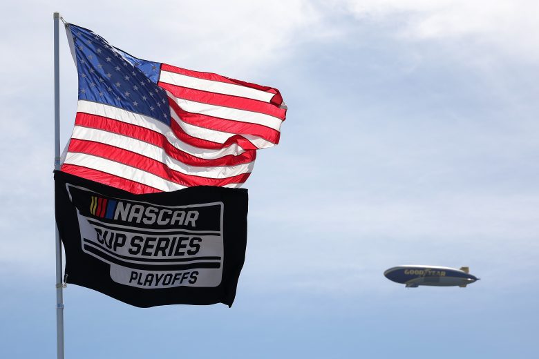 A general view of a United State flag and NASCAR Cup Series Playoffs flag waving in the foreground as a Goodyear blimp flies in the background at Homestead-Miami Speedway.