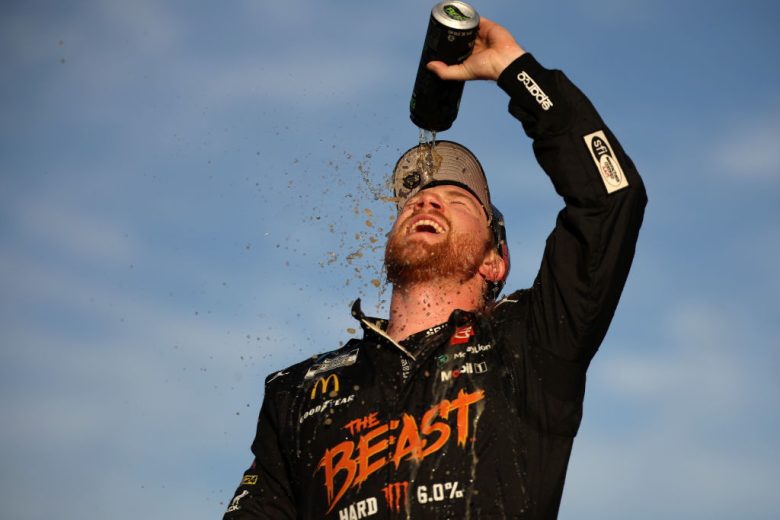 Tyler Reddick pours a beverage on his face in celebration.