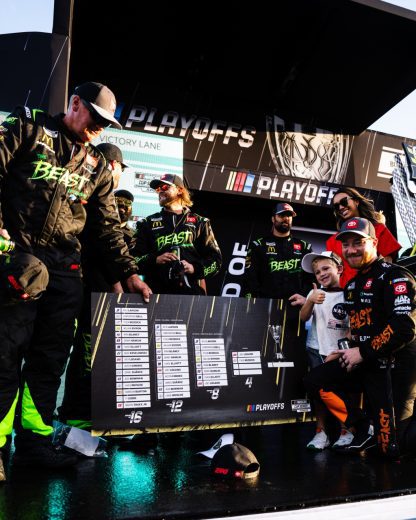 Tyler Reddick poses for a photo next to the NASCAR Cup Series Playoffs grid.