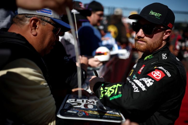 Tyler Reddick signs autographs.