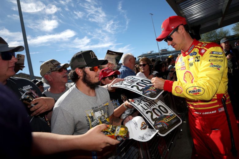 Joey Logano signs autographs.