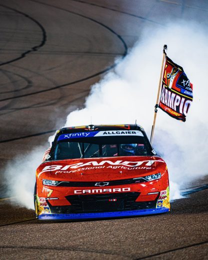 allgaier does a burnout with the champ trophy