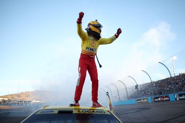 Joey Logano stands atop his No. 22 Team Penske Ford and celebrates.
