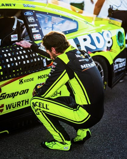 Ryan Blaney crouches next to his No. 12 Team Penske Ford.