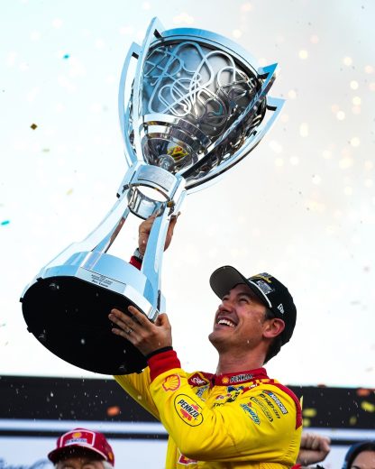 Joey Logano hoists the Bill France Cup.