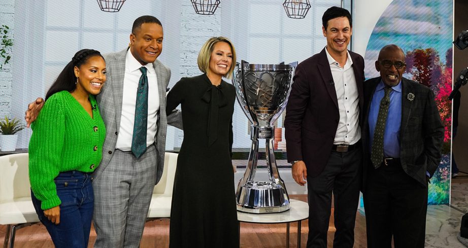 Joey Logano and the TODAY show crew stand next to the Bill France Cup.