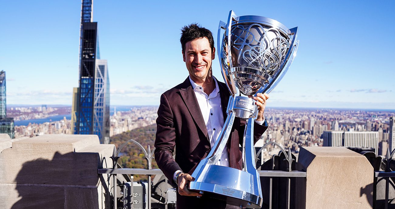 Joey Logano holds up Bill France Cup on top of skyscraper