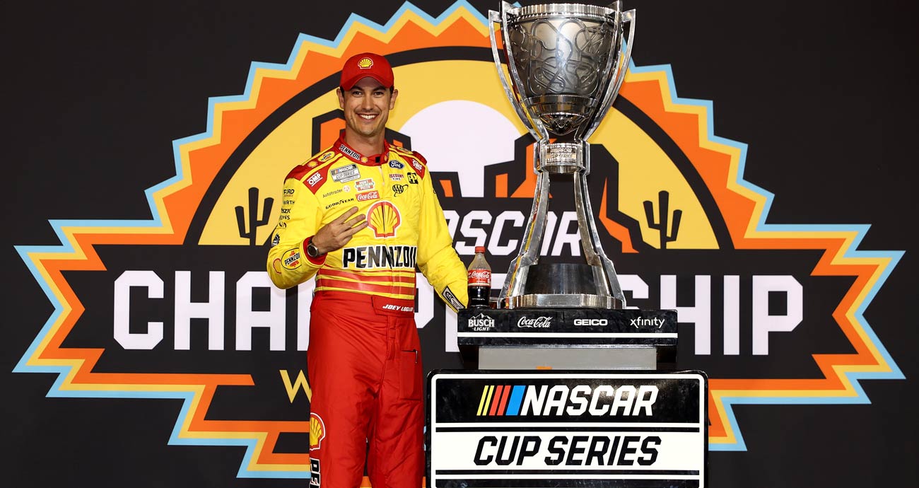 Joey Logano poses for a photo with the Bill France Cup in Victory Lane at Phoenix Raceway.