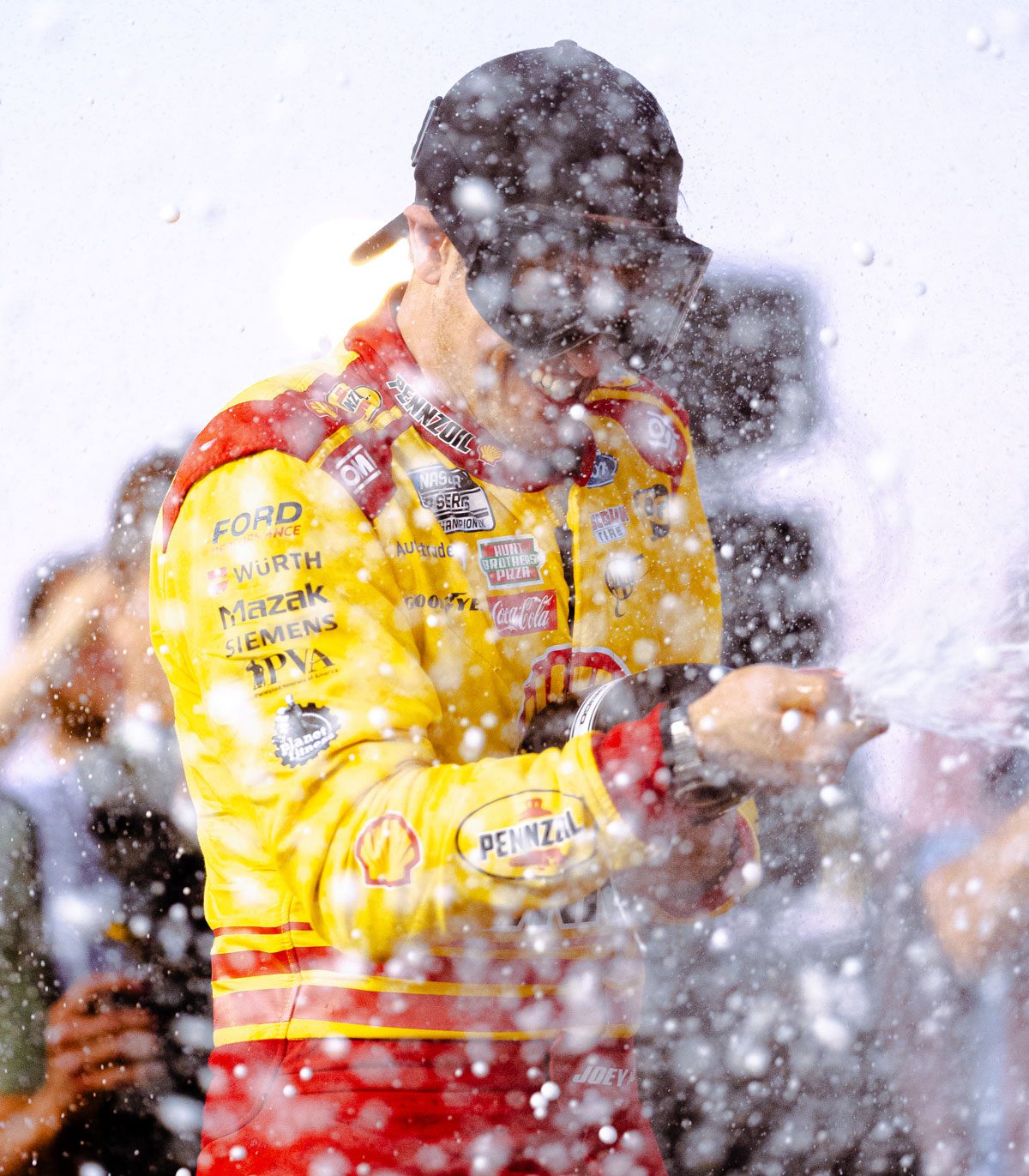 Joey Logano sprays champagne in Victory Lane