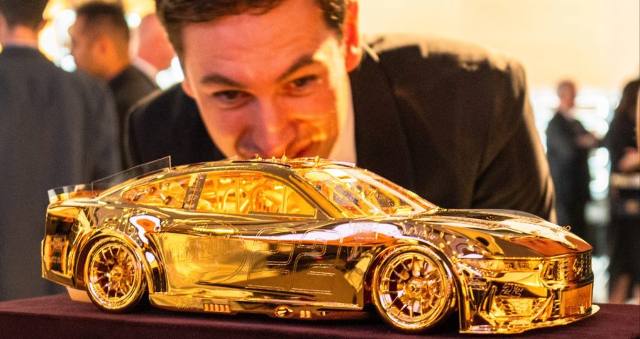 Joey Logano looks at the Goodyear gold car.