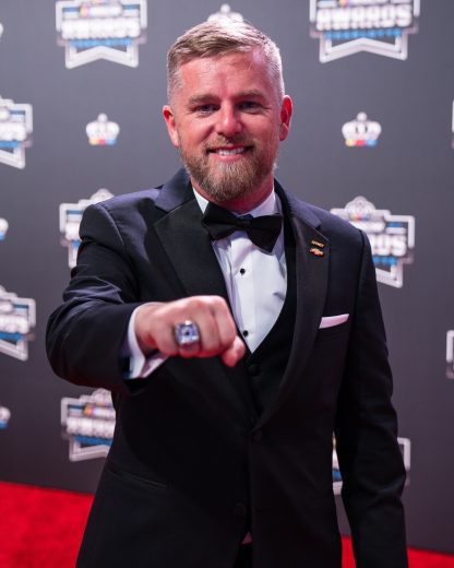 Justin Allgaier poses for photos on the red carpet.
