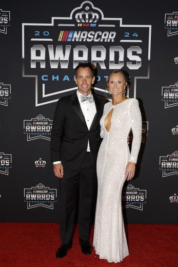 2024 NASCAR Cup Series champion crew chief Paul Wolfe (L) and wife Aleah Wolfe (R) pose for a photo on the red carpet.