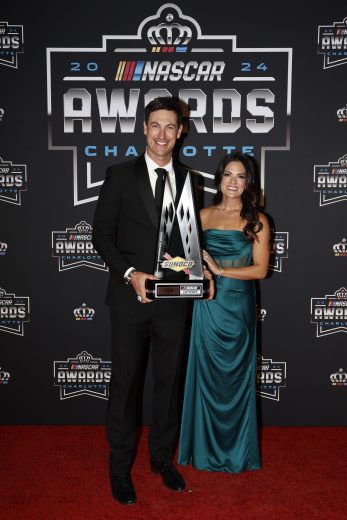 NASCAR Cup Series champion Joey Logano (L) and his wife Brittany Logano (R) pose for photos on the red carpet.