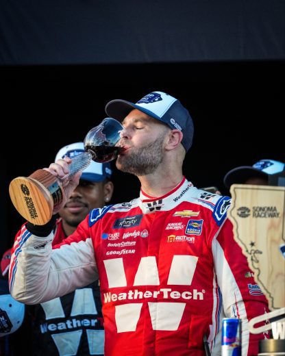 Shane van Gisbergen tastes the wine in Victory Lane following his NASCAR Xfinity Series win at Sonoma Raceway.