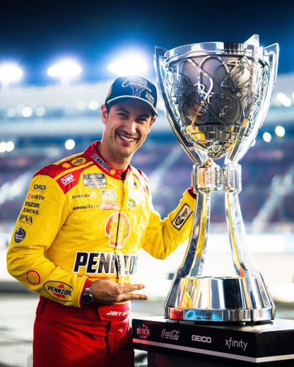 Joey Logano poses for a photo with the Bill France Cup following his NASCAR Cup Series Championship victory at Phoenix Raceway.