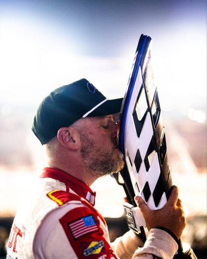Justin Allgaier kisses the NASCAR Xfinity Series Championship trophy.