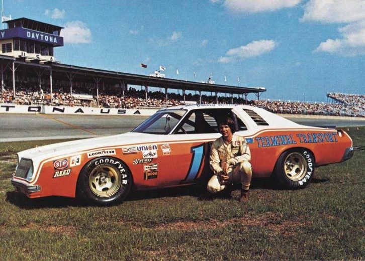 Darrell Waltrip looks on.