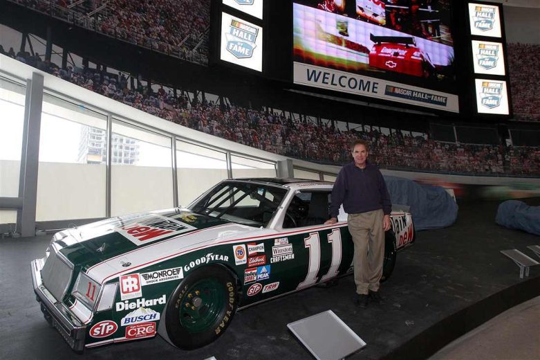 Darrell Waltrip looks on.