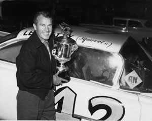 Lee Petty holds a trophy.