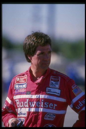 Darrell Waltrip looks on.
