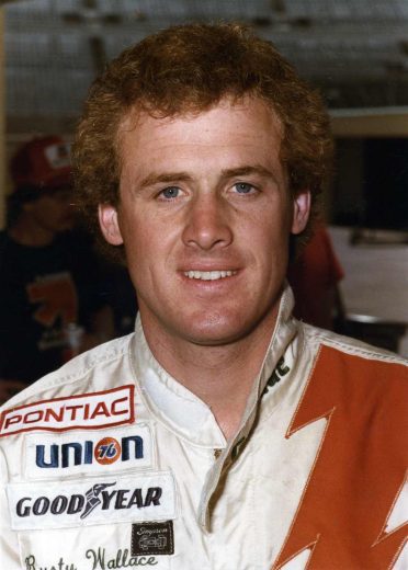 Rusty Wallace looks on.