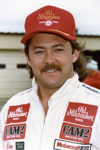 Tim Richmond smiles and looks on.