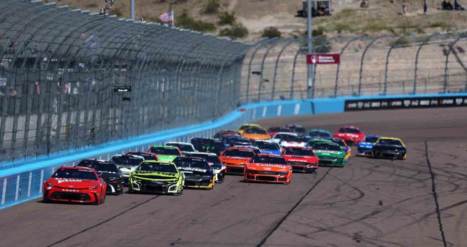 NASCAR Cup Series cars race down the backstretch at Phoenix Raceway.
