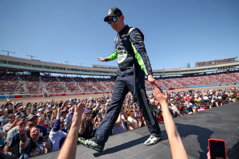 Kyle Busch walks across the stage and greets fans before a NASCAR Cup Series race at Phoenix Raceway.