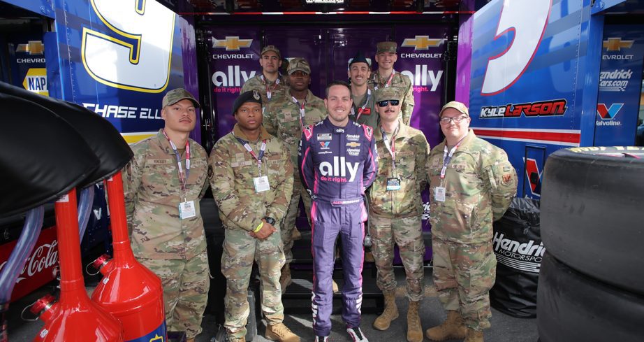 Alex Bowman poses with members of the United States Air Force outside the No. 48 hauler at Las Vegas Motor Speedway.