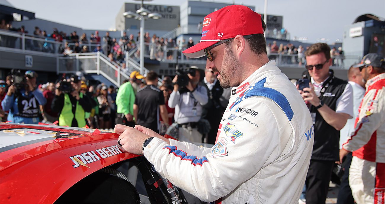 Josh Berry, driver of the No. 21 Motorcraft/Quick Lane Ford, places the winner sticker on his car in victory lane