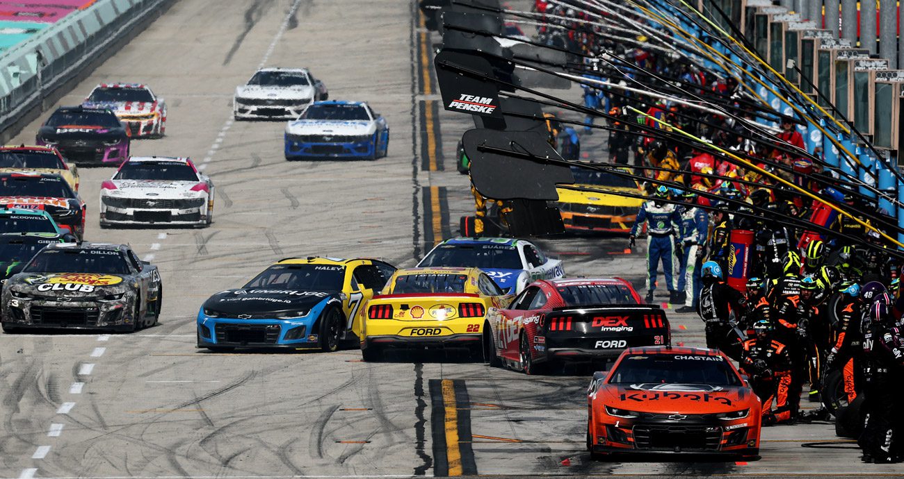 Joey Logano and Josh Berry slide backwards on pit road at Homestead after contact.