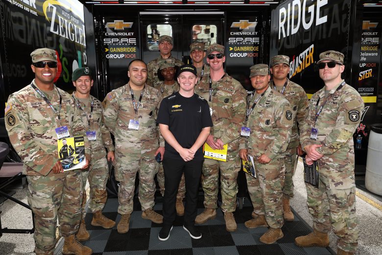 Justin Haley poses for a photo with United States military members at Homestead-Miami Speedway.