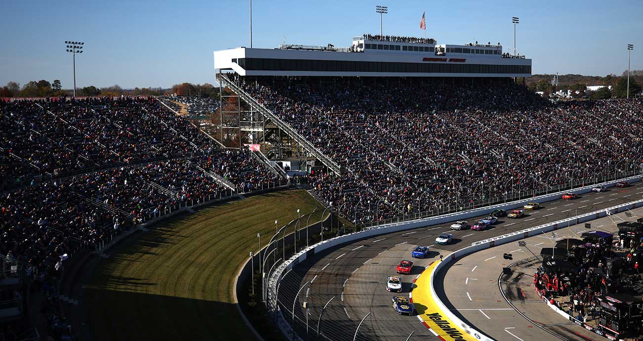 The Cup Series field roars into Turn 1 in front of packed grandstands at Martinsville Speedway