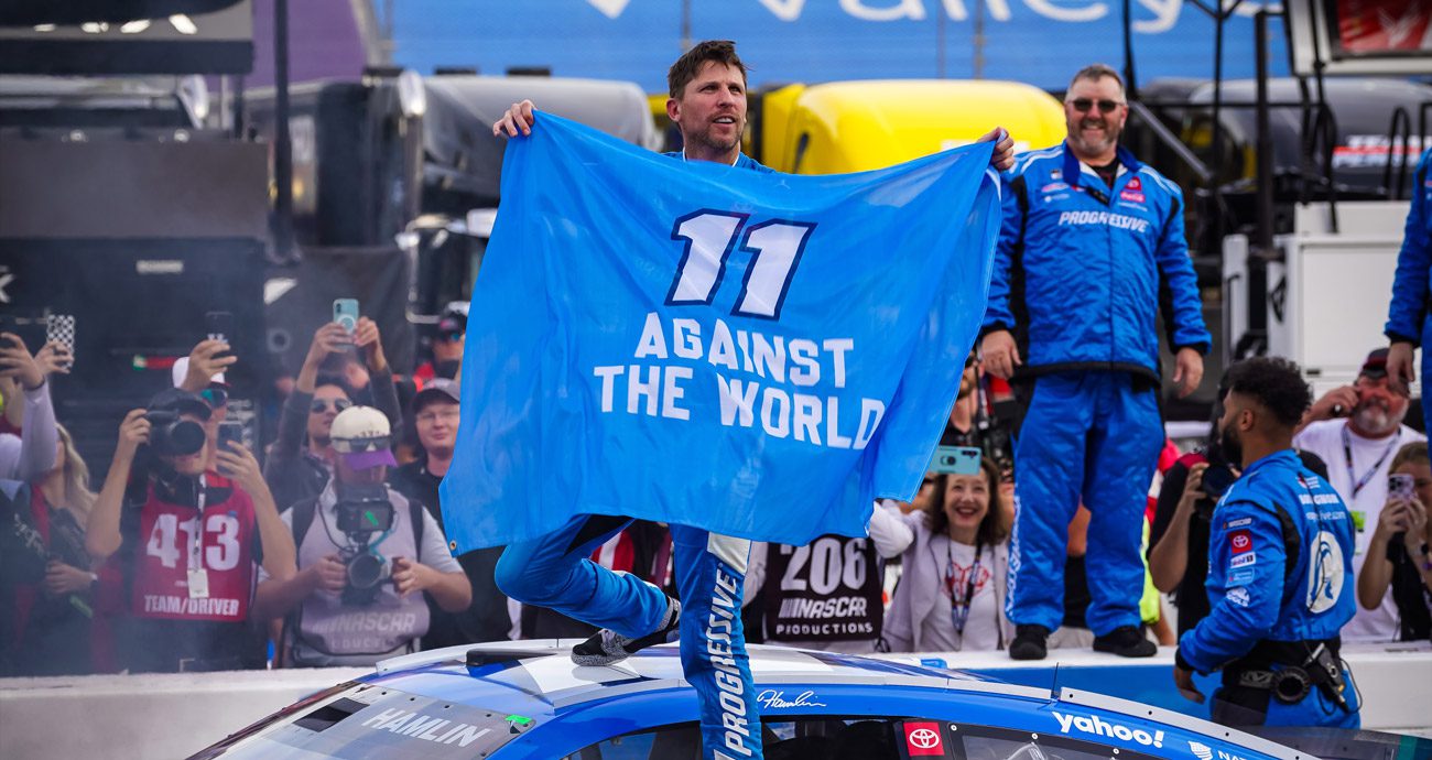 Denny Hamlin celebrates a Martinsville win with a flag that reads, '11 against the world.'