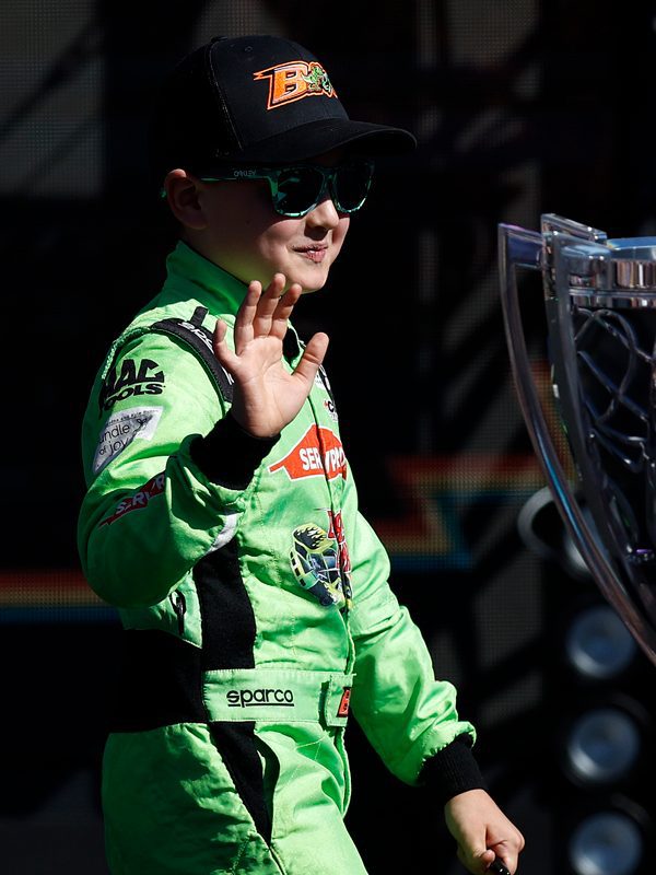 Brexton Busch, the son of NASCAR Cup Series driver, Kyle Busch, waves to fans as he walks onstage during driver intros prior to the NASCAR Cup Series Championship at Phoenix Raceway.