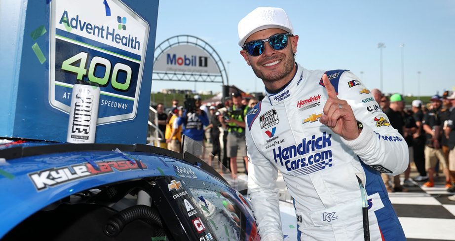 Kyle Larson places winner sticker on car.